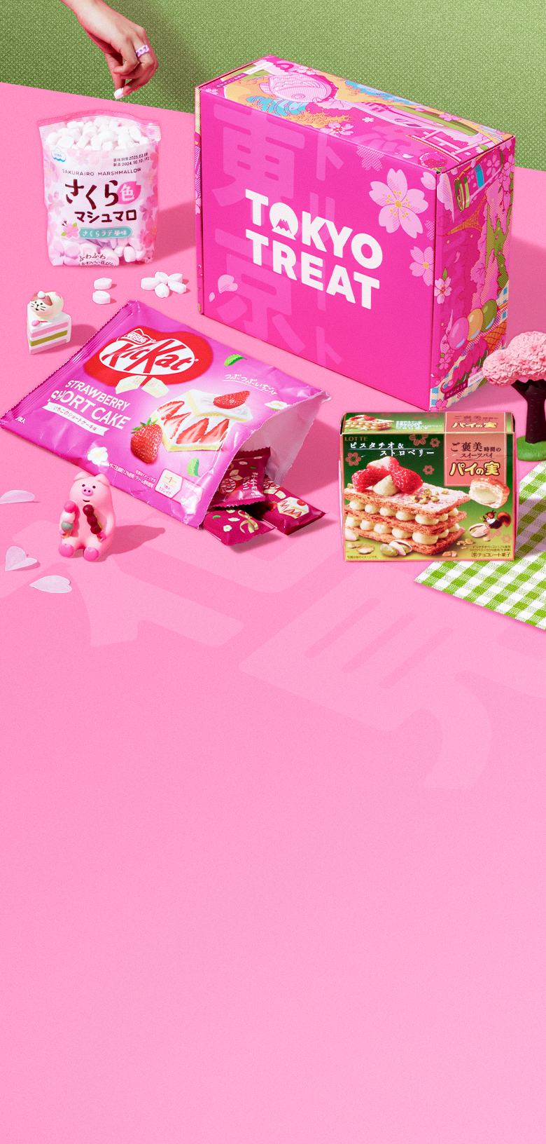 TokyoTreat's delicious Cherry Blossom Bites box surrounded by Japan-exclusive snacks like KitKats, chips, and candy.