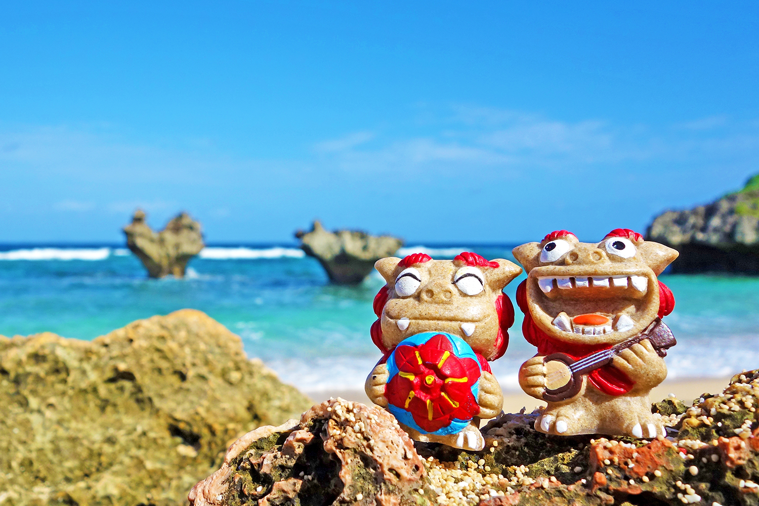 Two Shisa lion-dog statues sit on an Okinawan beach.