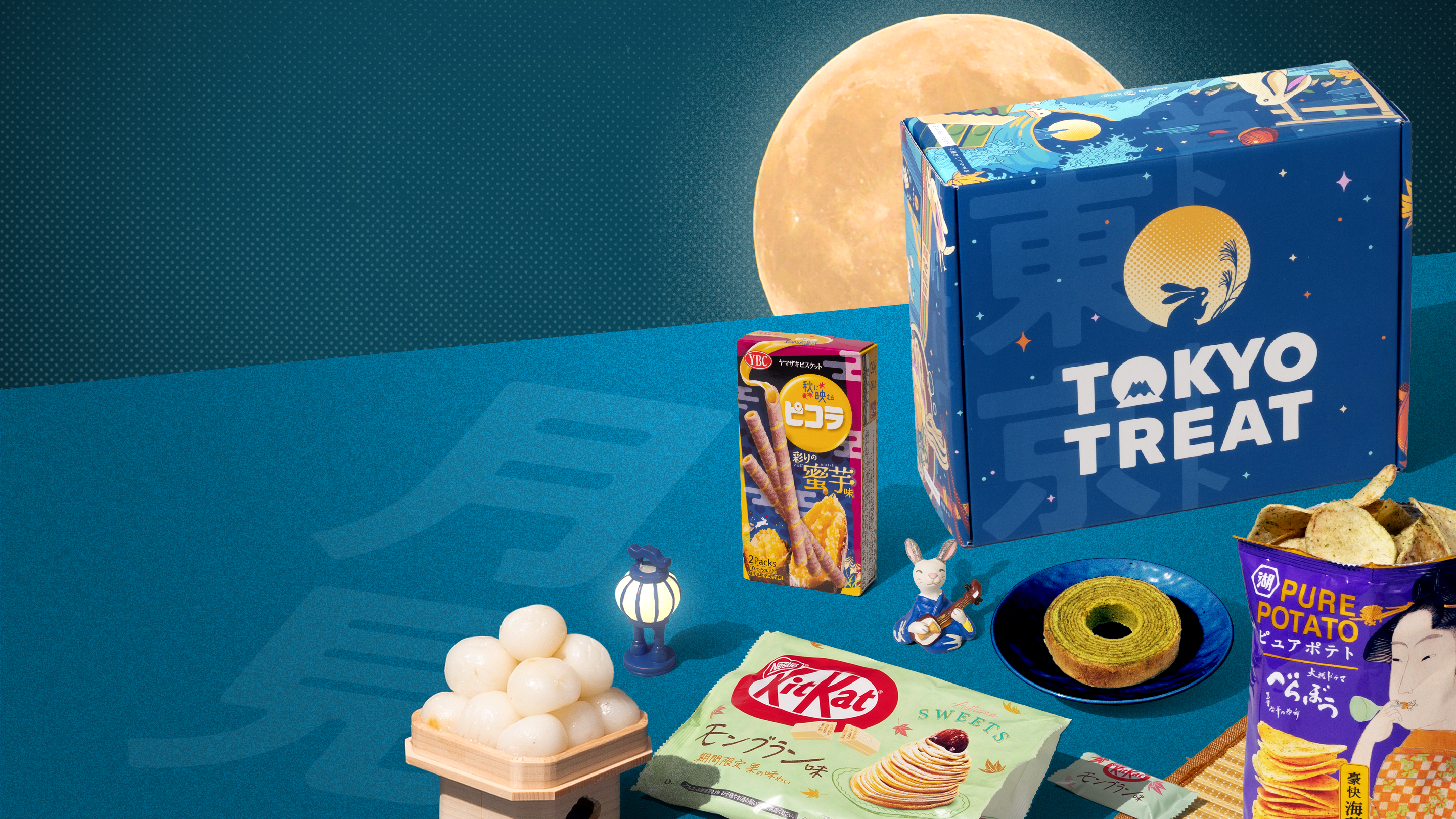 TokyoTreat tsukimi box with moon-themed snacks around it on blue background with moon 