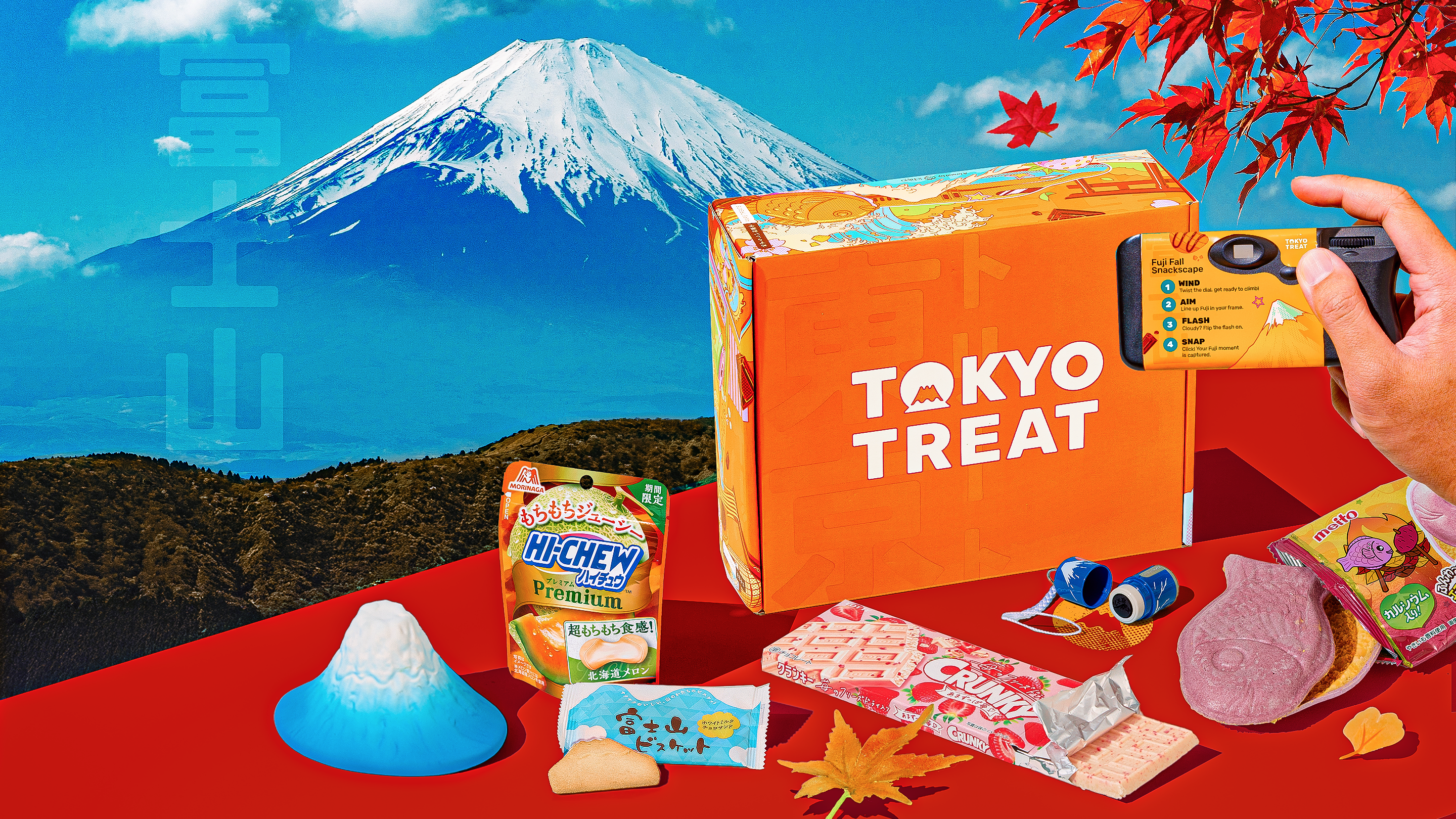 Orange TokyoTreat box with fall snacks around it and Mt. Fuji in the background 