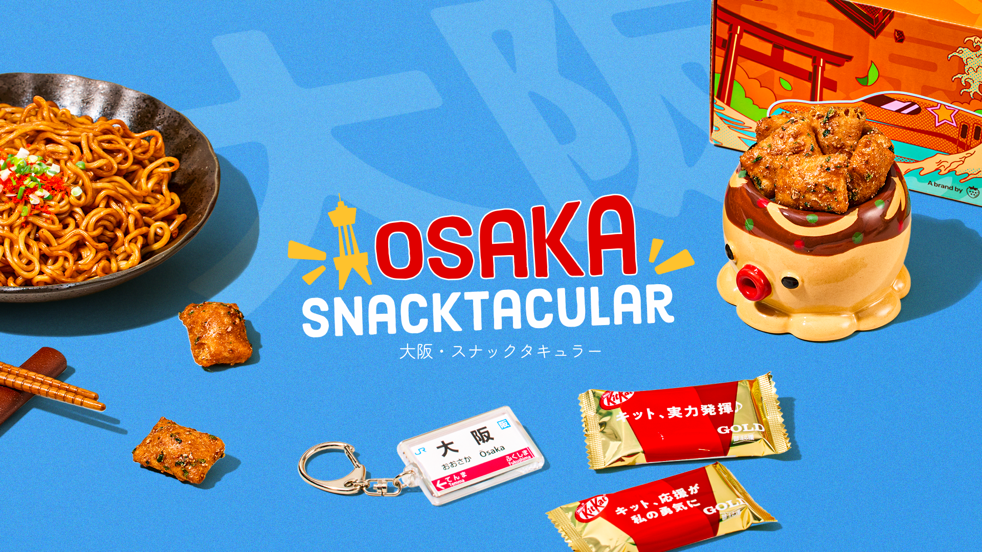 Orange TokyoTreat box with Osaka-themed snacks around it on blue background 