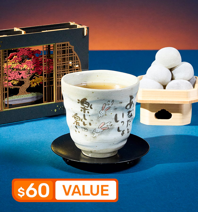 Mochi, tea cup, and papercraft diorama on a blue background