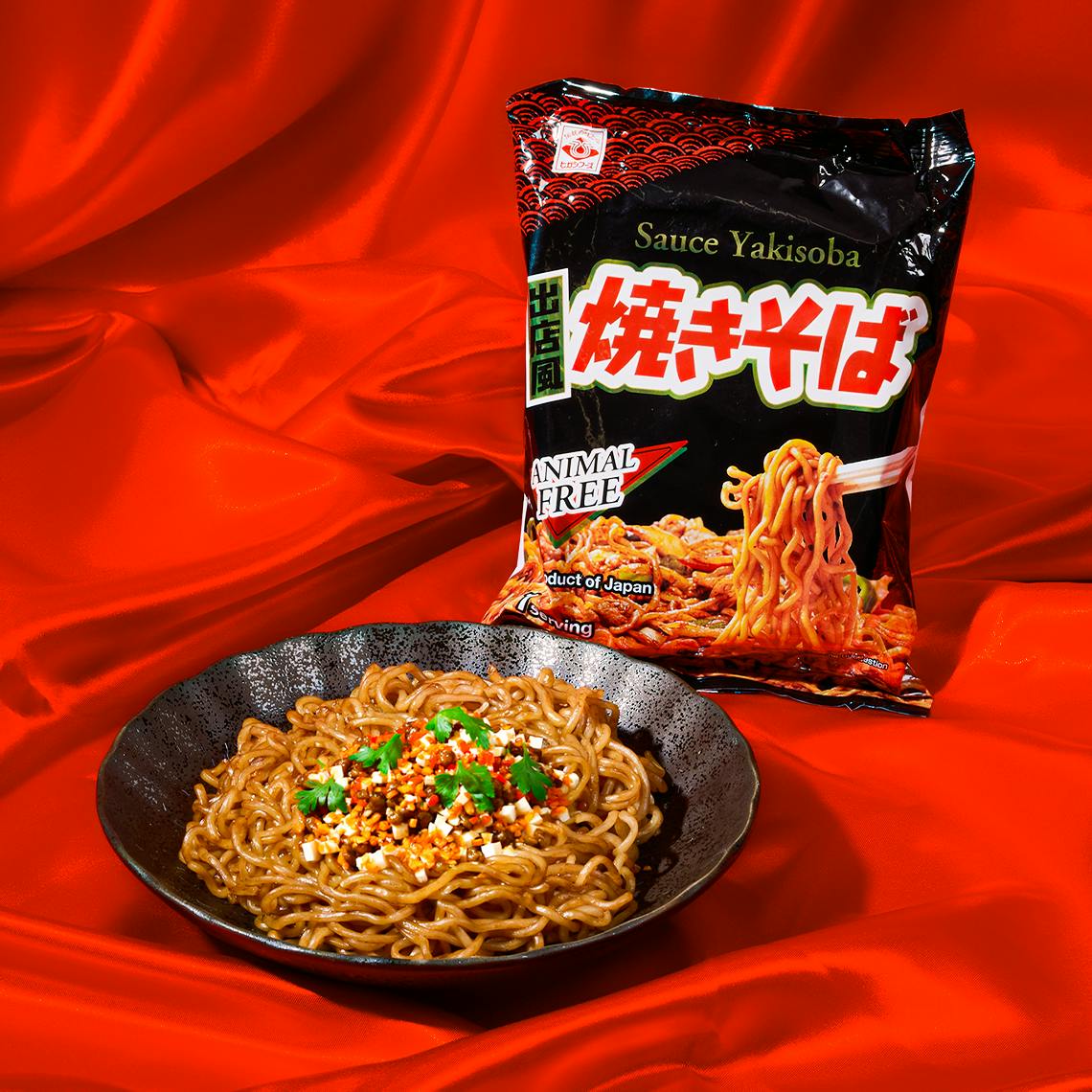 A bowl of yakisoba noodles in a red background