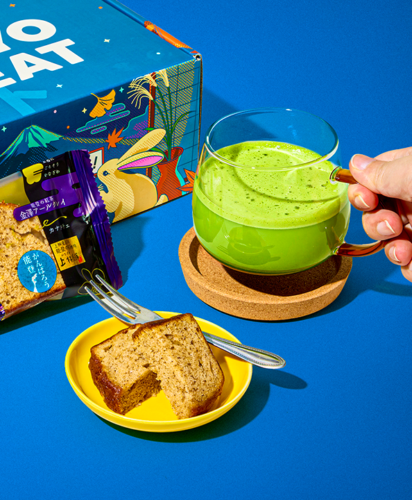 Matcha drink and a piece of cake on a blue background