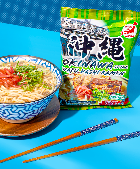 A bowl of ramen with chopsticks in a blue background
