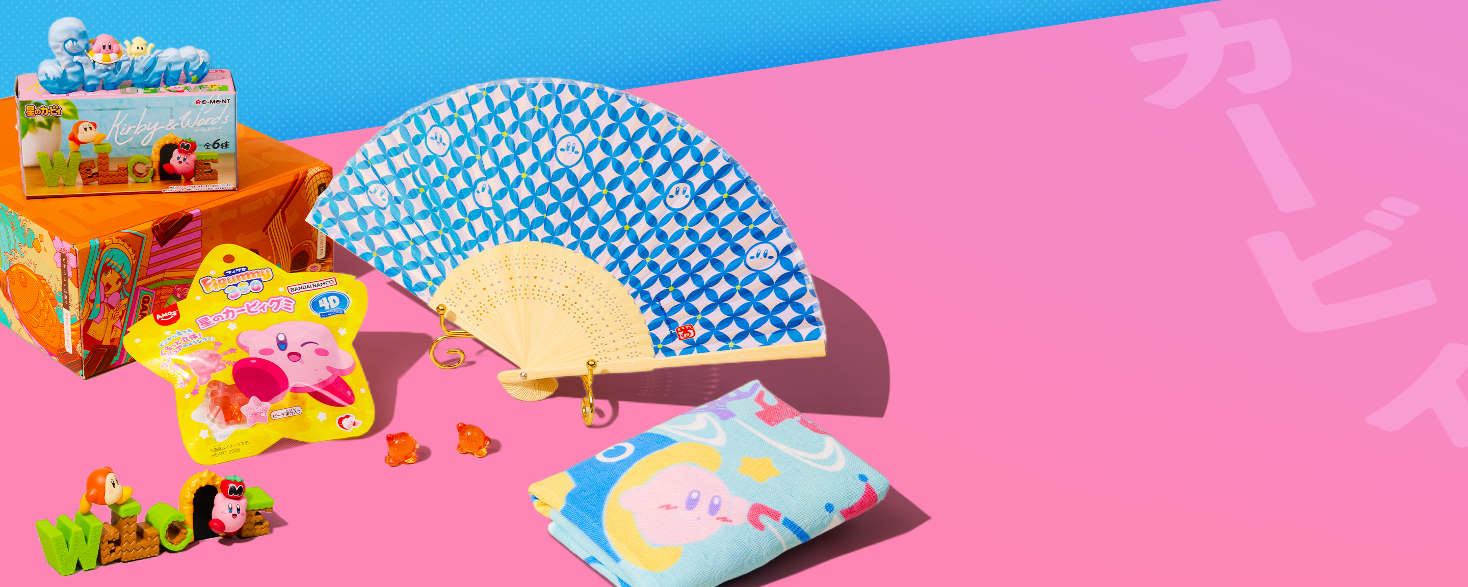 A Kirby beach towel, fand and a snack on a blue and pink background