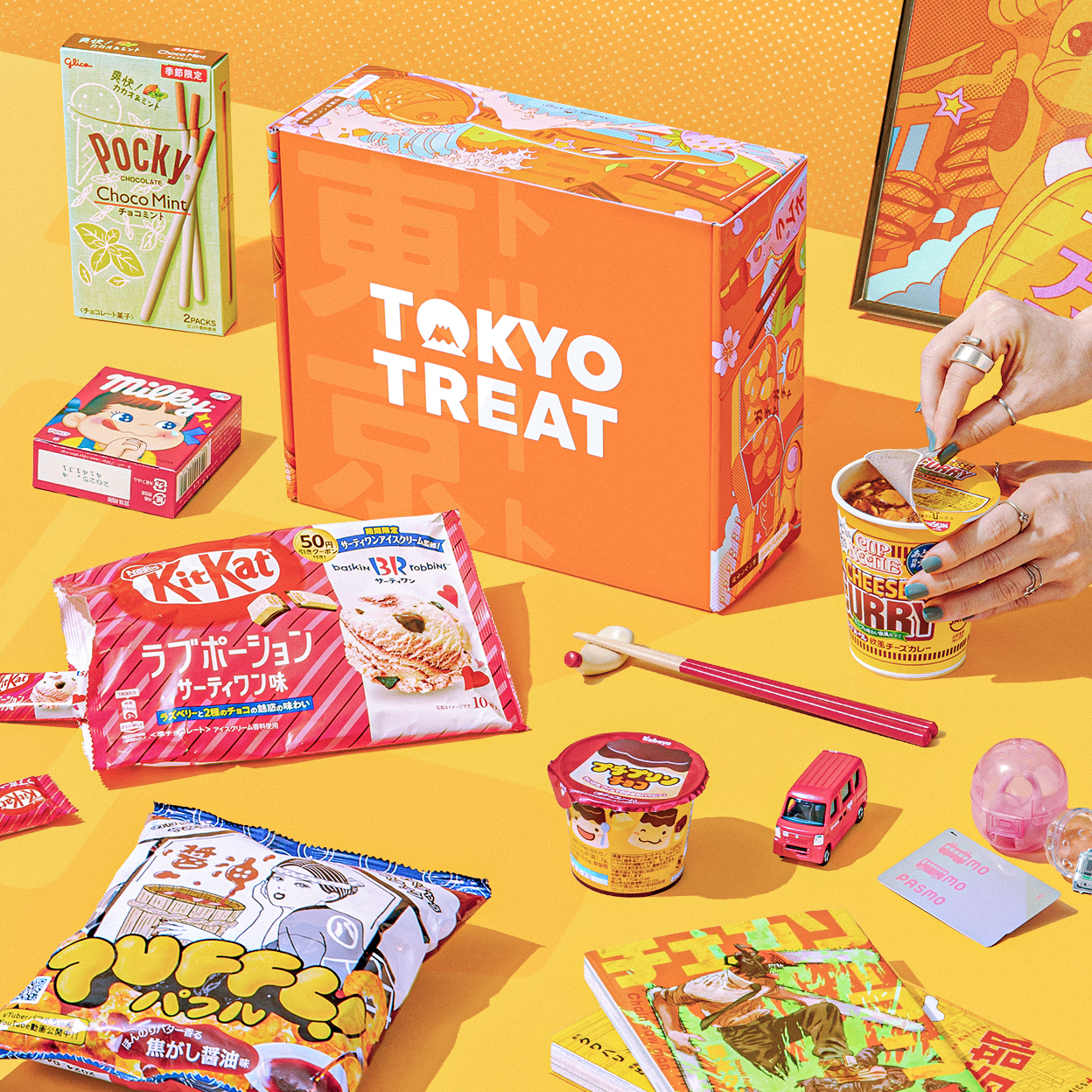 Orange TokyoTreat box with snacks around it on yellow background