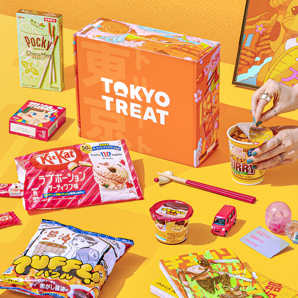 Orange TokyoTreat box with snacks around it on yellow background