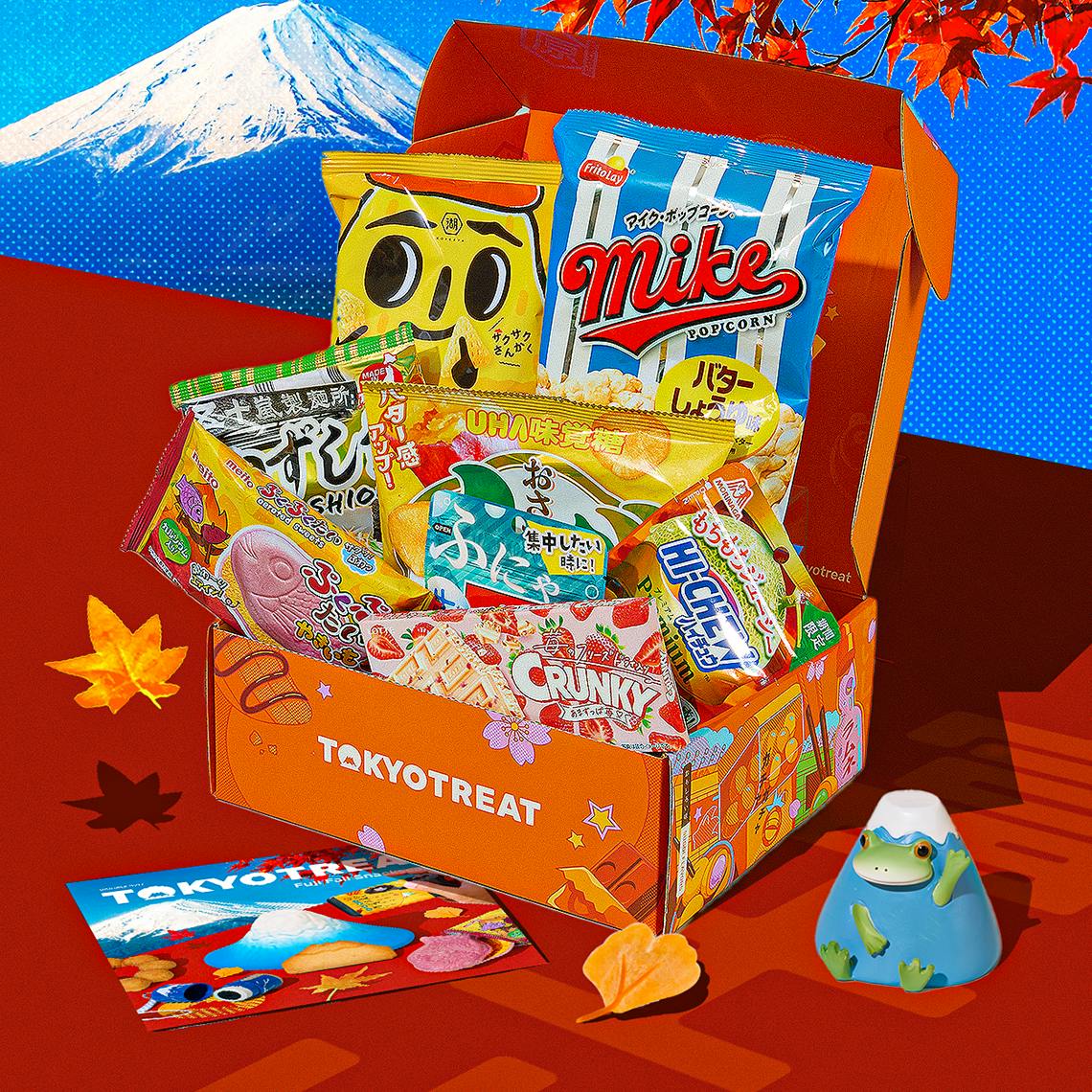 Orange TokyoTreat with fall snacks on red background with Mt. Fuji in the back