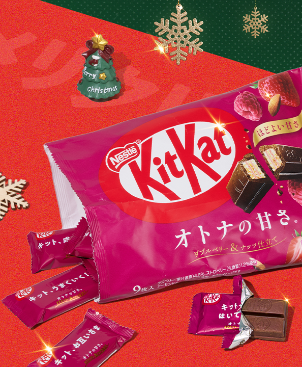 KitKats on red background with Christmas figurine and snowflake ornaments around it
