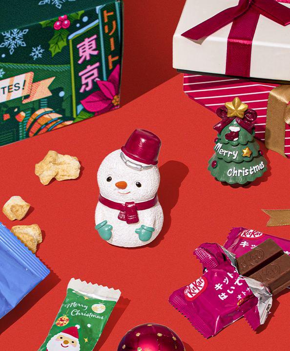 Cute little snowman figurine on red background with Christmas snacks around it