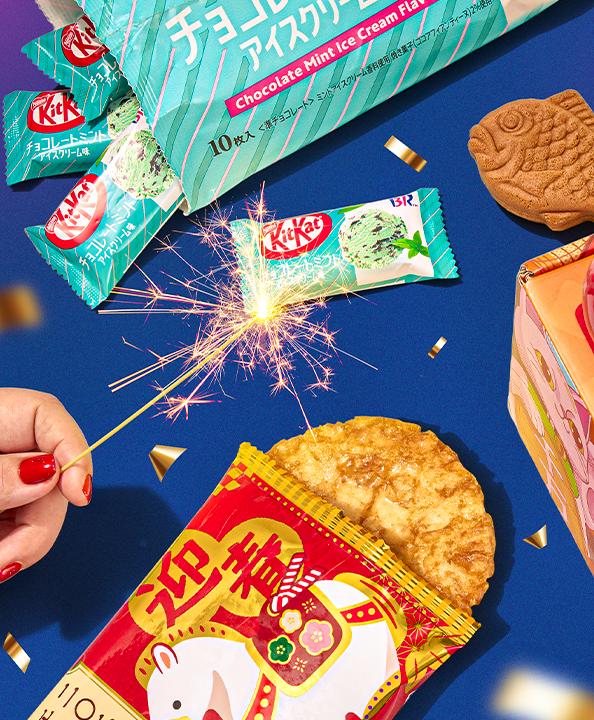 New Year treats on dark blue background with sparkler in the middle