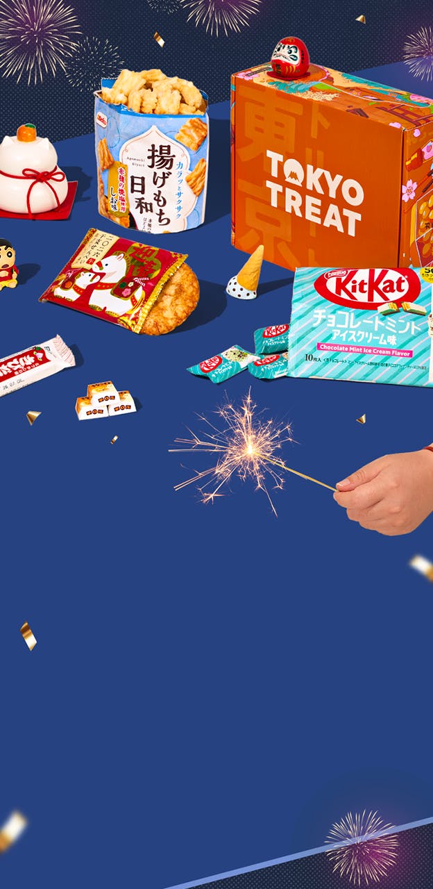 Orange TokyoTreat box on blue background with Japanese New Year-themed snacks with maneki neko figure