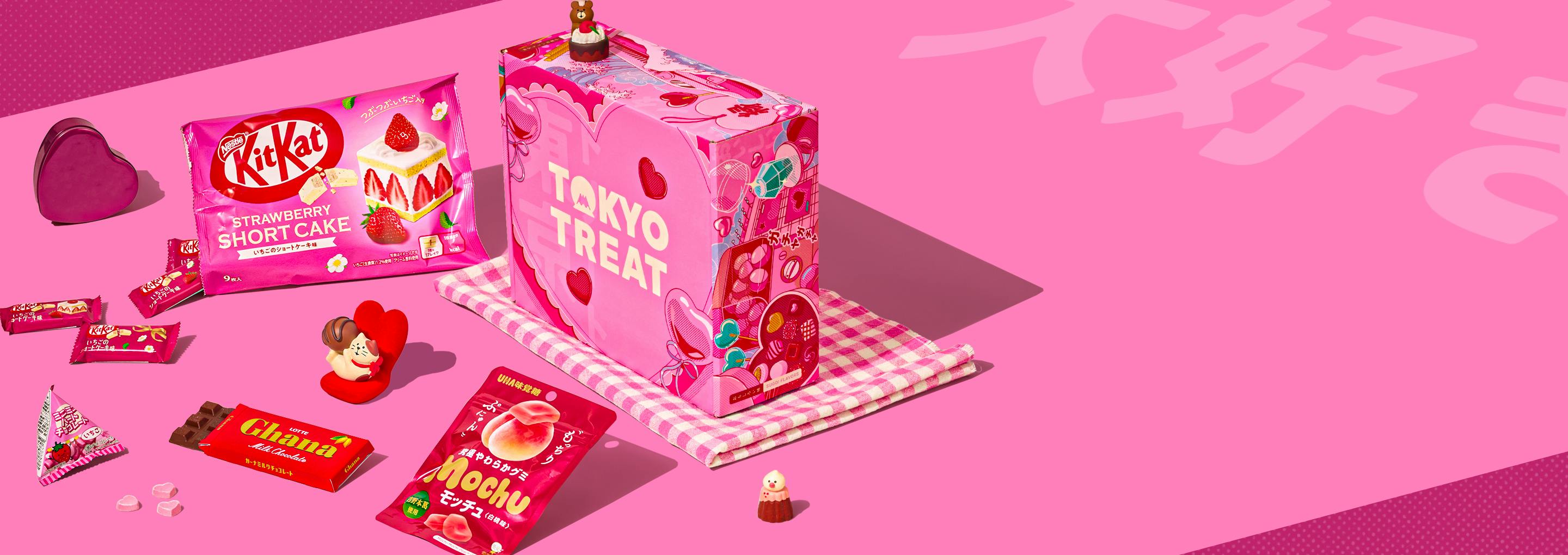 TokyoTreat Valentine's box with lots of red and pink snacks next to it on a pink background