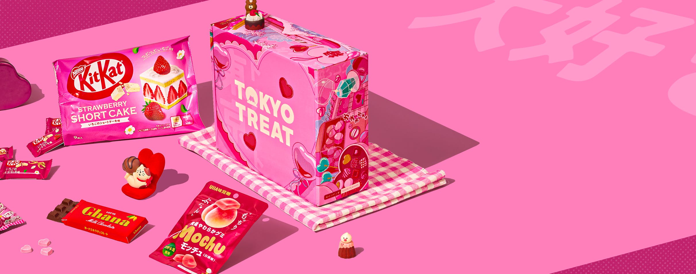 TokyoTreat Valentine's box with lots of red and pink snacks next to it on a pink background