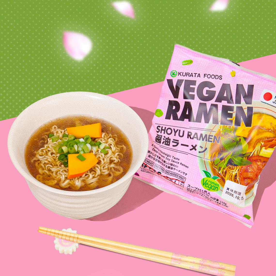 Bowl of vegan ramen with chopsticks on pink background with petals falling down in the background