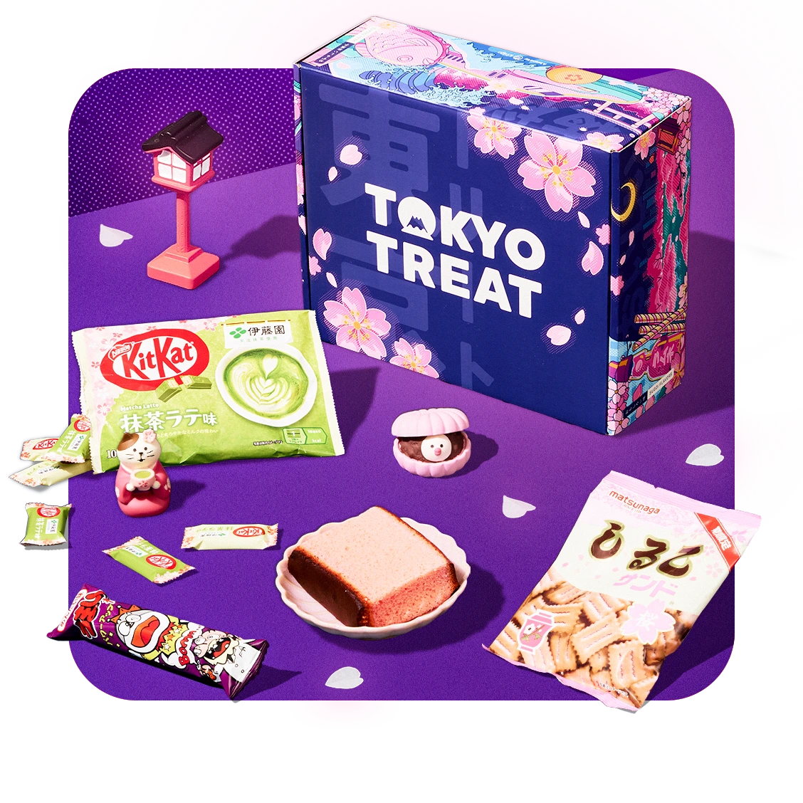 TokyoTreat box with sakura-themed snacks around it on purple background