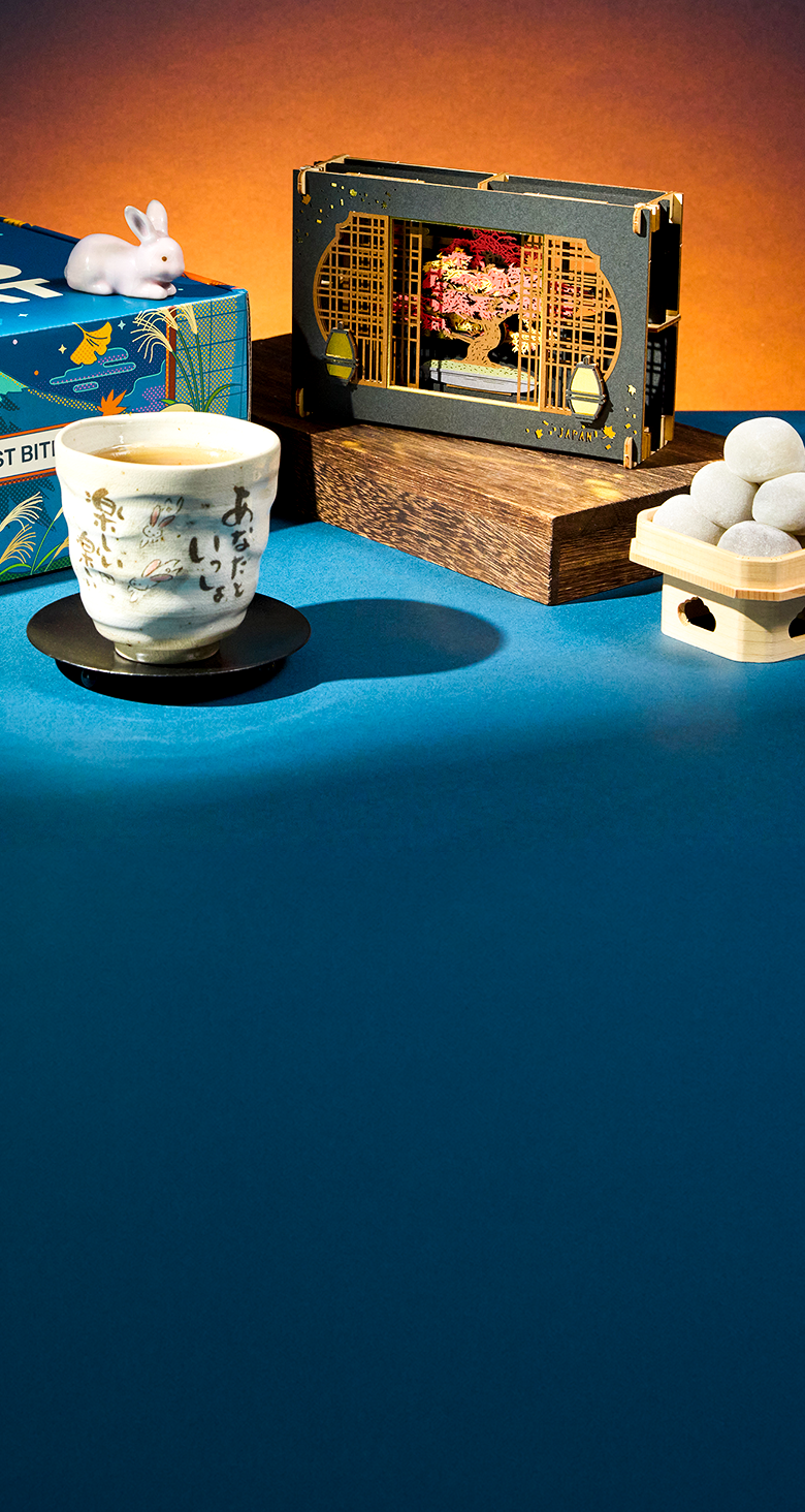 Mochi, a tea cup, and papercraft diorama on a blue background
