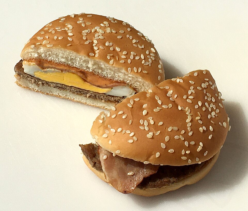 Burger sliced in half on a plain background