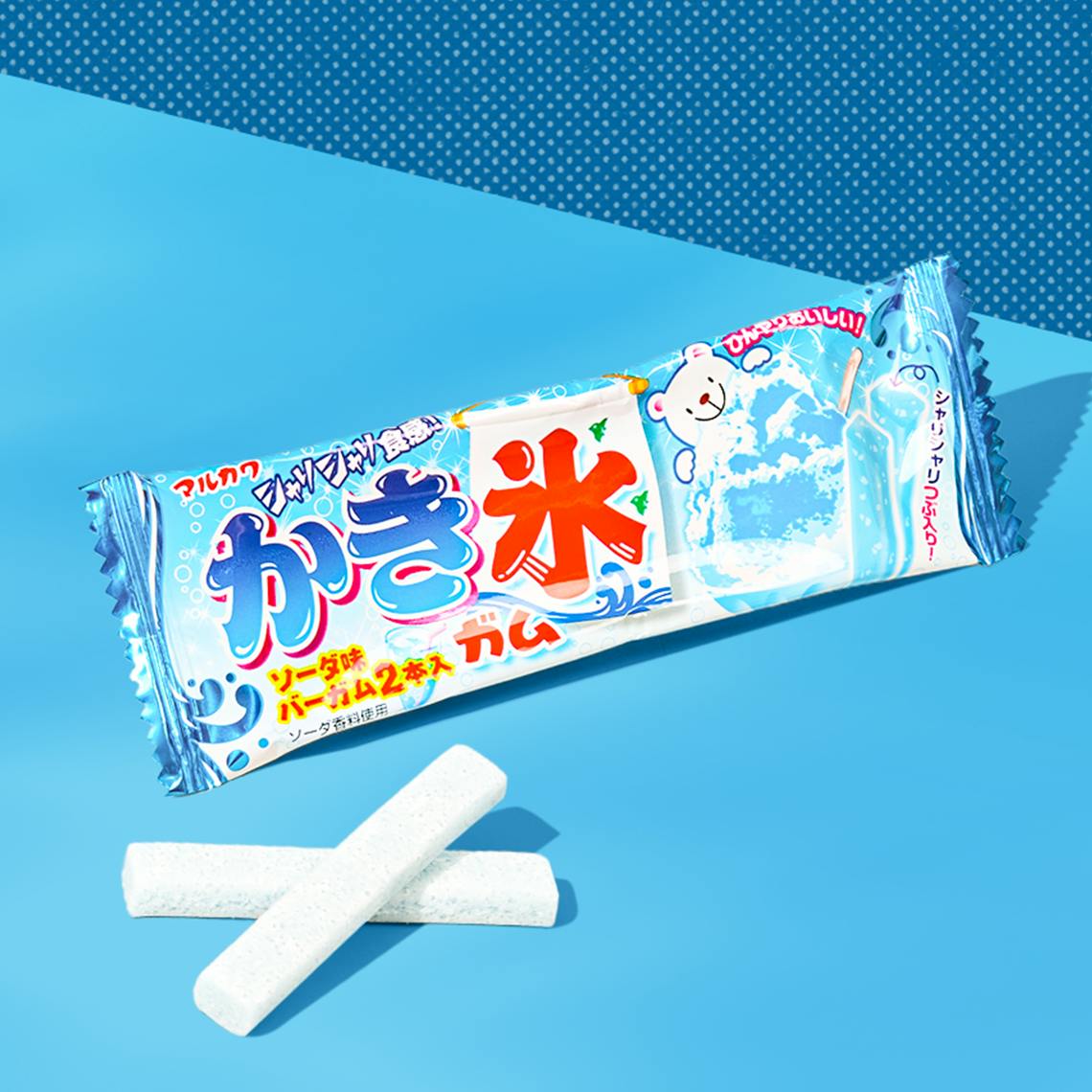 A pack of bar gum with a bear in the wrapper in blue background